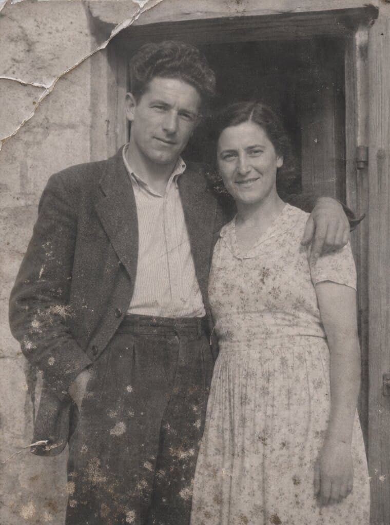 Un jeune couple sur le seuil d’une ferme en pierre, en 1938.
